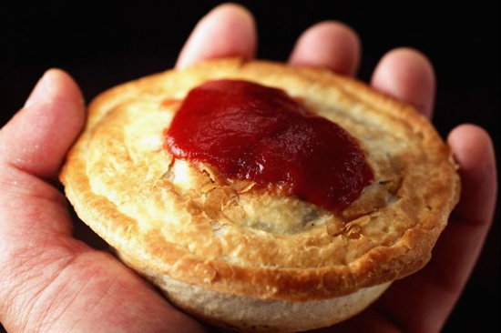 Empanadas de carne o pie sostenida en una mano